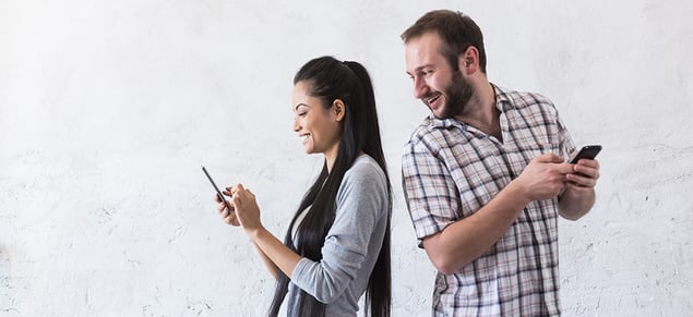 GettyImages-Guy looking over womans shoulder smiling_980x450