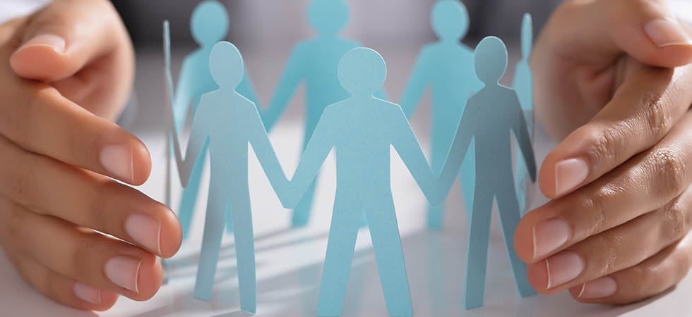 GettyImages_hands around blue paper cut out people_980x450