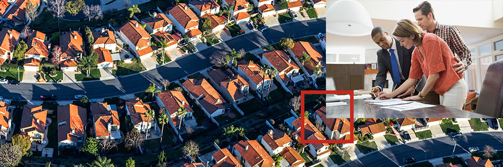 Arial shot of suburbs with an overlay of 3 people signing paperwork on a desk