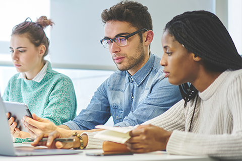 Three colleagues sitting in an office working together 