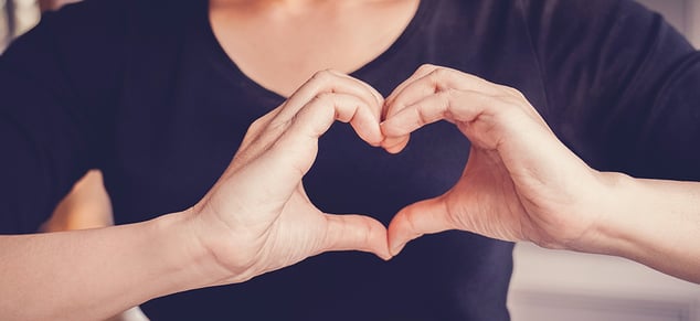 Woman Forming Heart with Hands_GettyImages_980x450